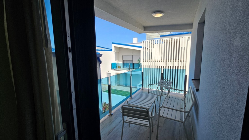 Balcon couvert avec garde-corps en verre et coin salon