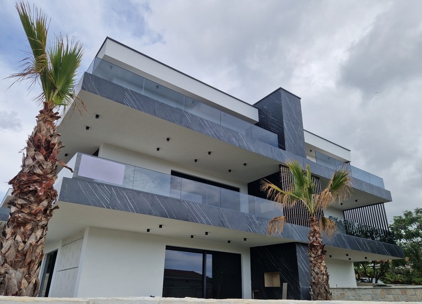 Maison avec garde-corps en marbre sombre et palmiers devant