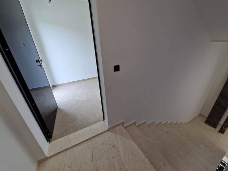 Cage d'escalier avec marches et porte d'entrée de l'appartement
