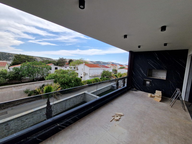 Balcon couvert avec garde-corps en verre et vue sur les maisons voisines