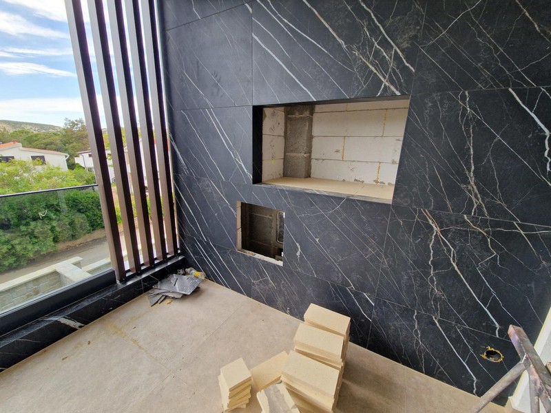 Balcon avec mur en pierre sombre et niche pour un barbecue