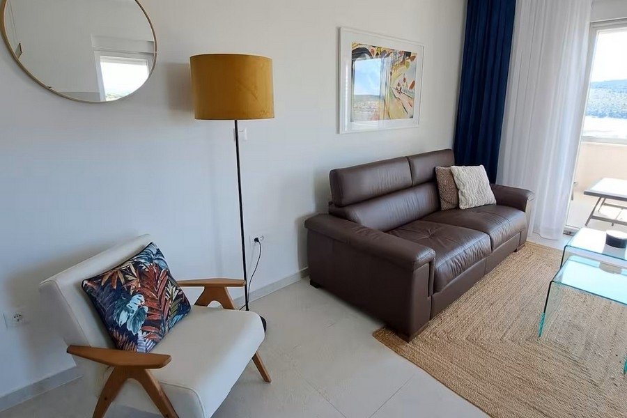 Séjour clair avec canapé en cuir et vue mer