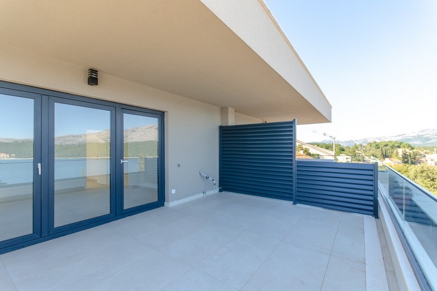 Terrasse couverte avec garde-corps en verre et vue mer