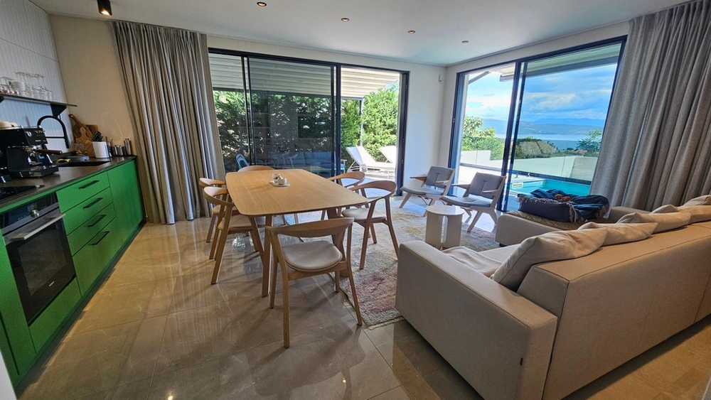Cuisine ouverte avec table à manger et vue mer