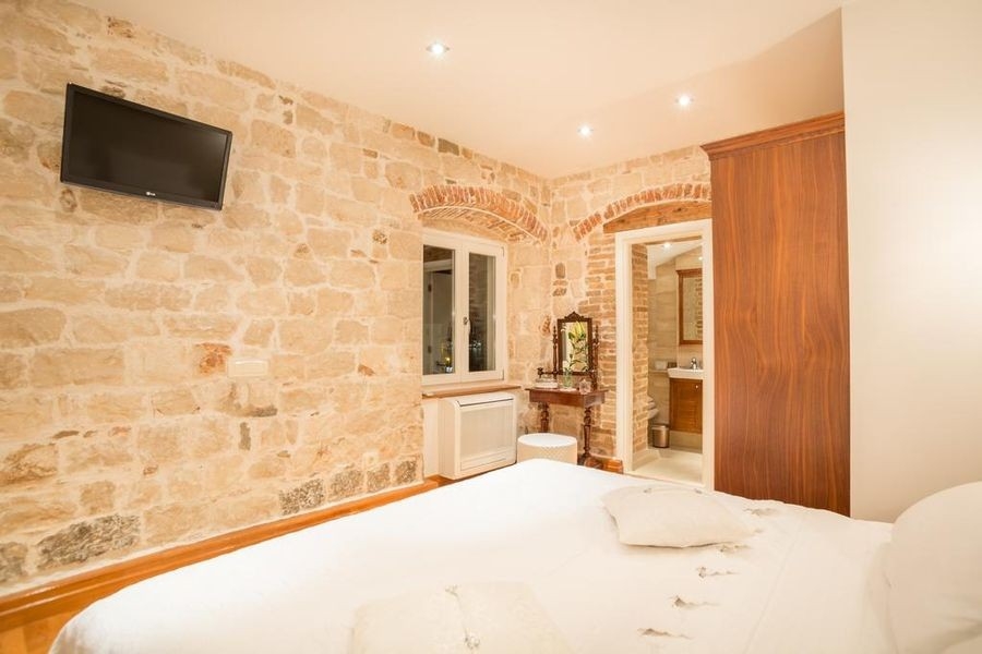 Chambre avec mur en pierre naturelle et lit double