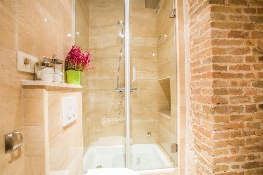 Salle de bains avec douche et mur en pierre naturelle