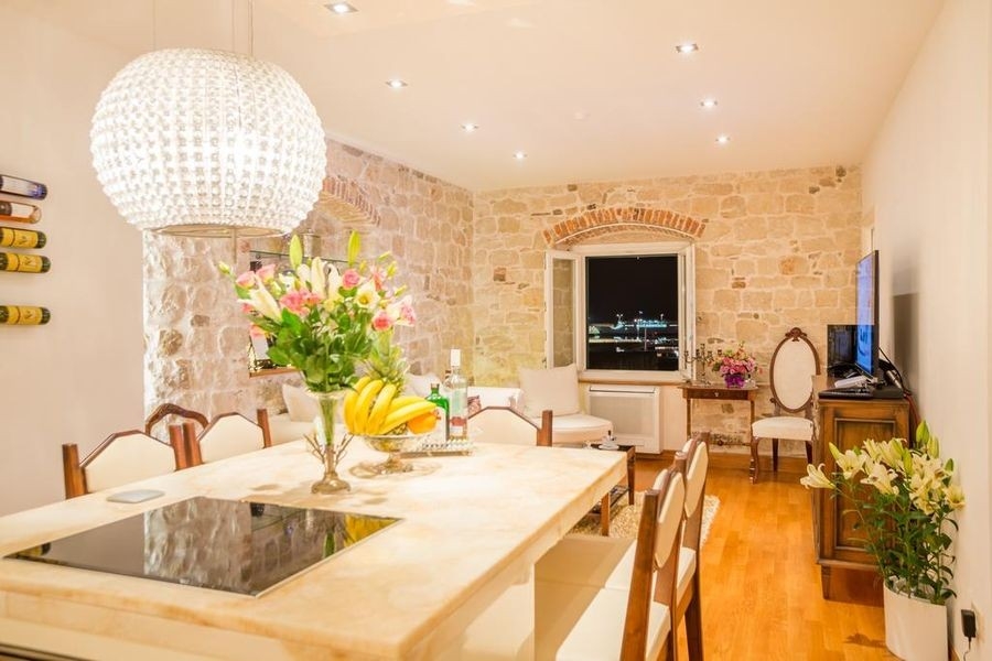 Espace repas avec mur en pierre naturelle et parquet