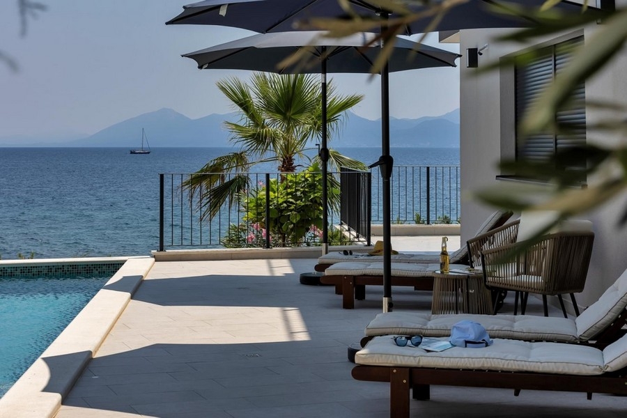 Terrasse de la piscine avec palmier et vue sur la mer