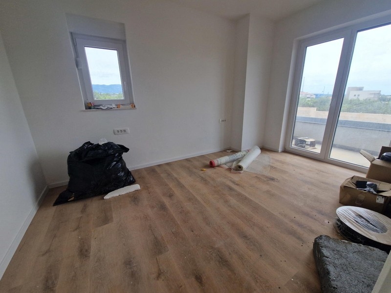 Pièce claire avec parquet et porte de la terrasse