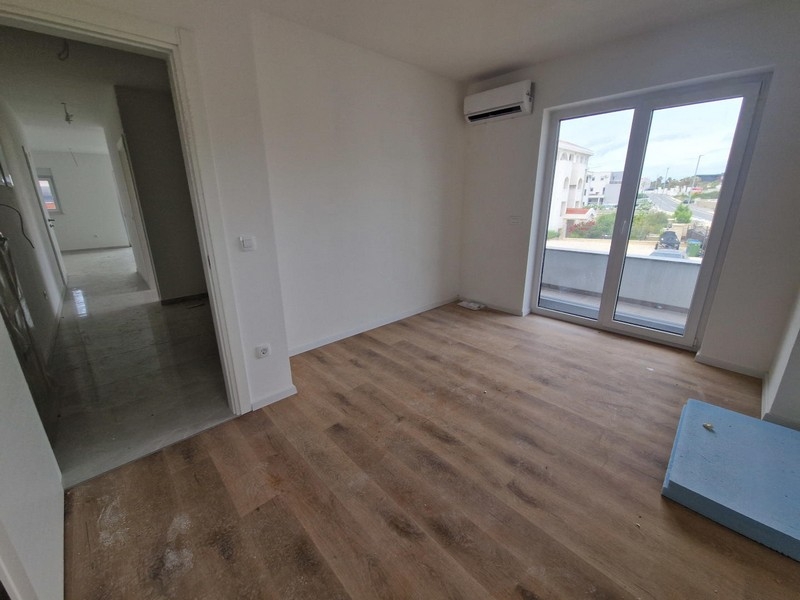 Pièce avec parquet et accès au balcon