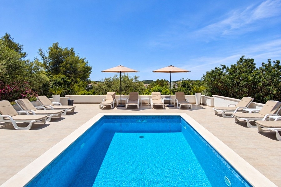Piscine commune avec transats et vue mer