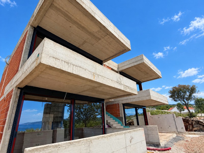 Balcons en béton superposés avec façades vitrées et escalier extérieur