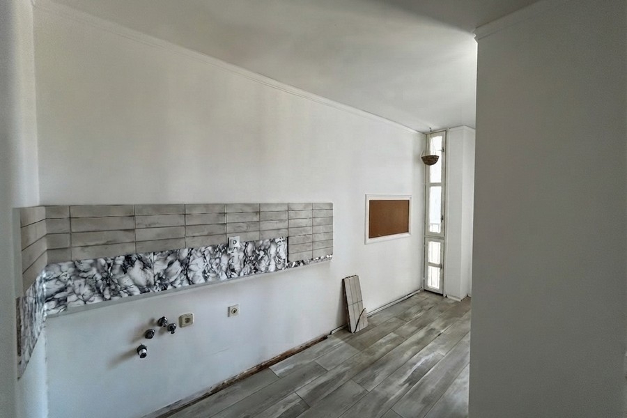 Coin cuisson avec mur carrelé et fenêtre