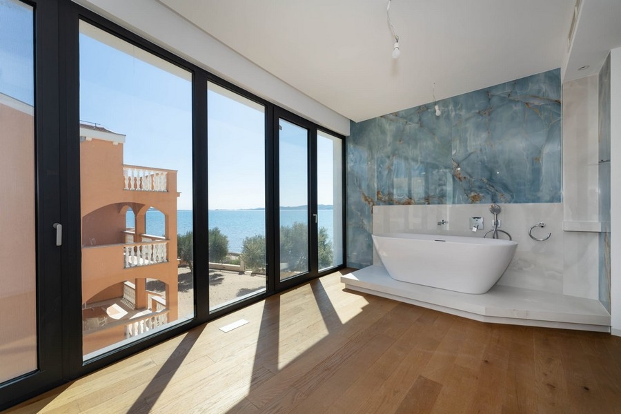 Salle de bains avec baignoire îlot et vue mer