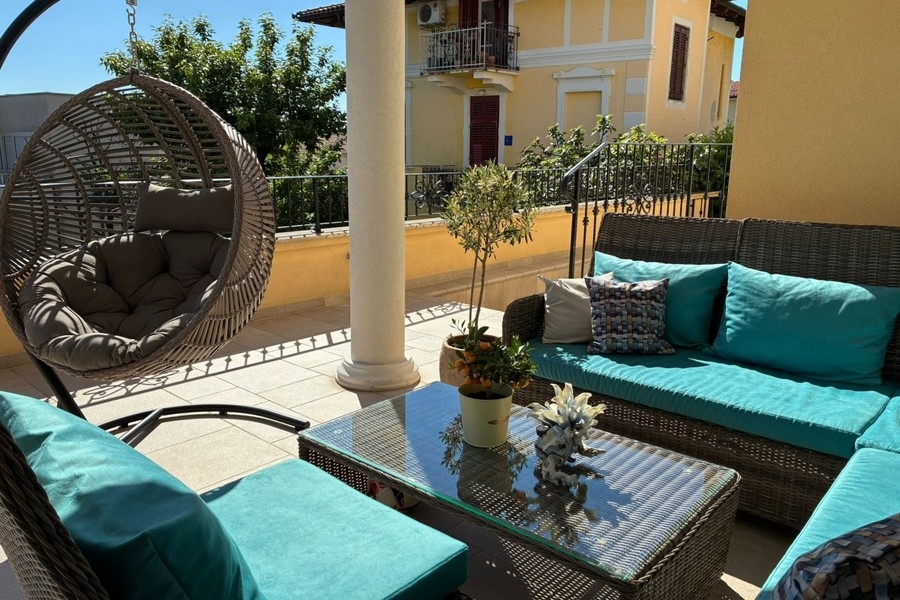 Terrasse avec mobilier lounge et fauteuil suspendu en Croatie