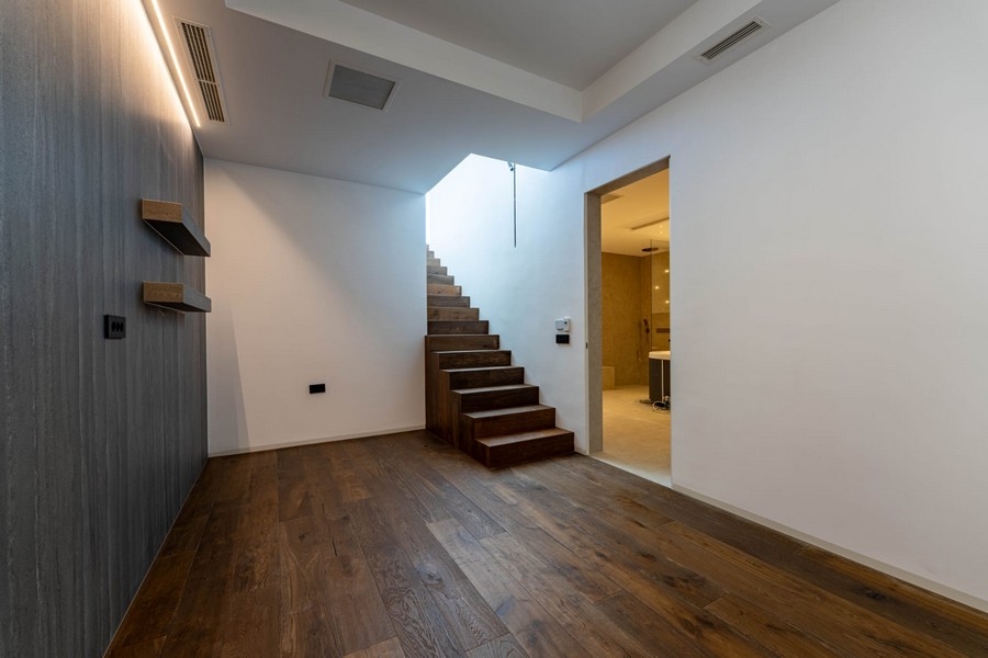 Entrée avec escalier en bois et salle de bains au sous-sol