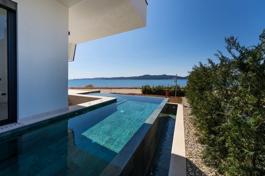 Piscine de l'appartement avec plantations et la mer à l'arrière-plan