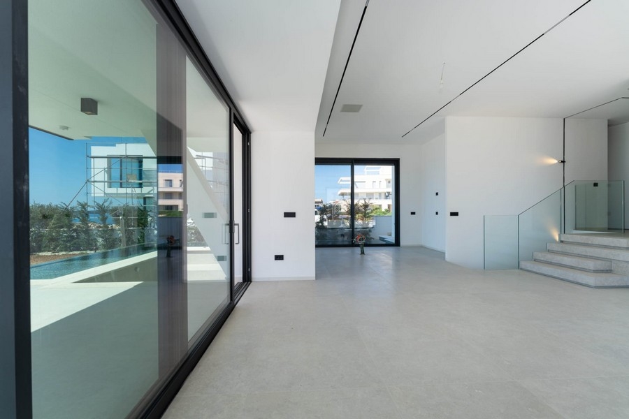 Séjour ouvert avec grandes surfaces vitrées et escalier