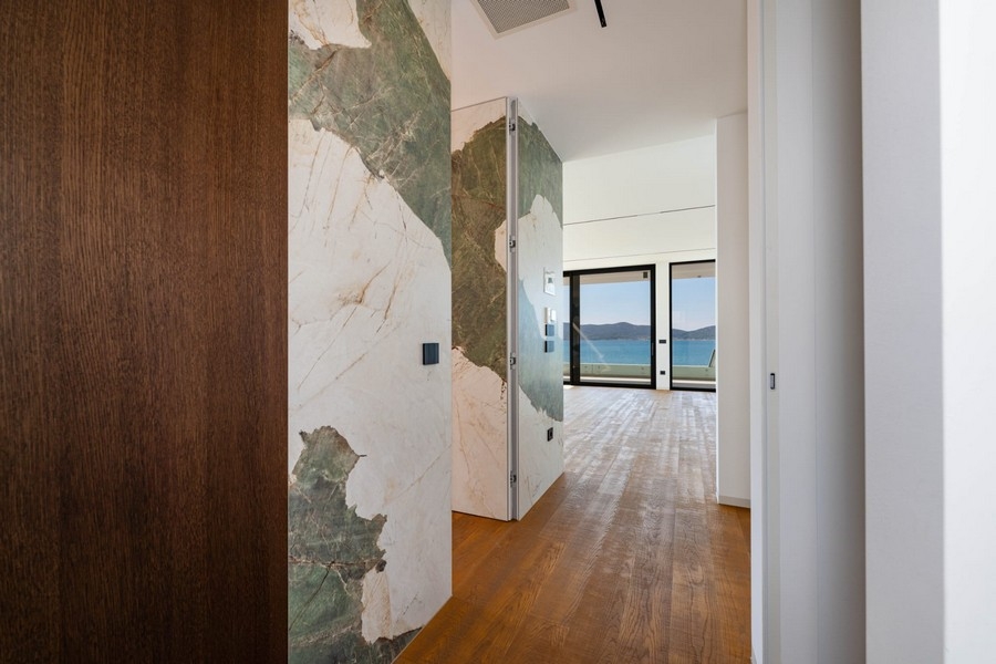 Entrée avec mur en marbre et vue sur le séjour