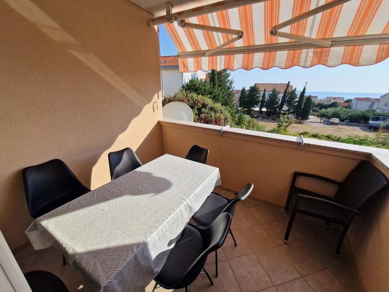 Loggia avec table et chaises sous le store banne