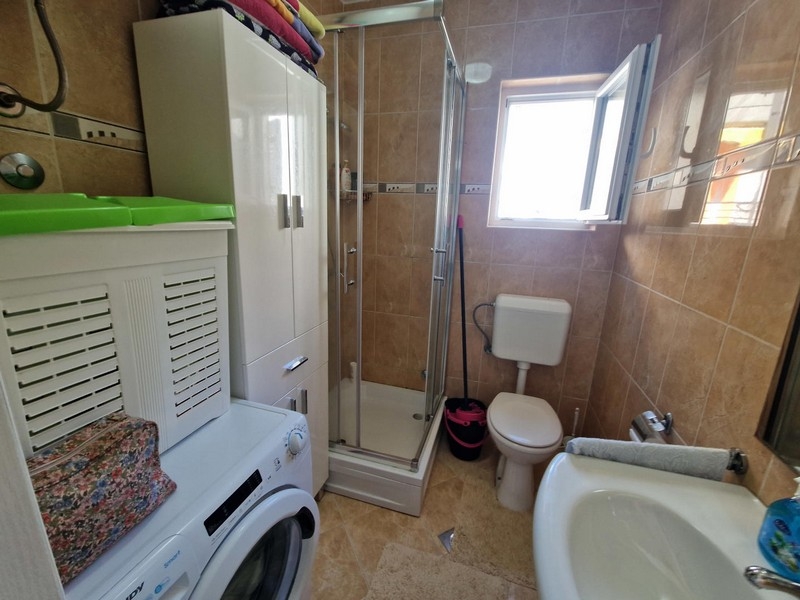 Salle de bains avec cabine de douche et lave-linge