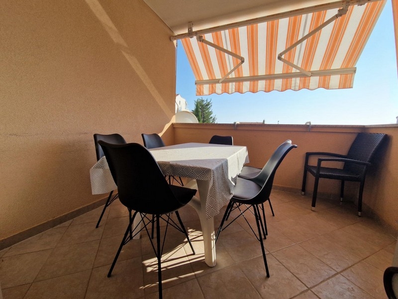 Loggia avec coin salon sous le store banne