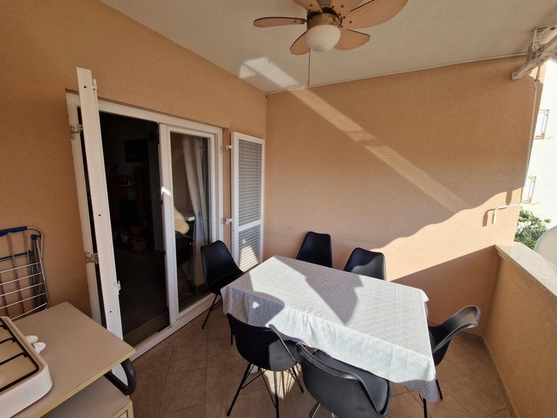 Séjour avec table et porte donnant sur la loggia