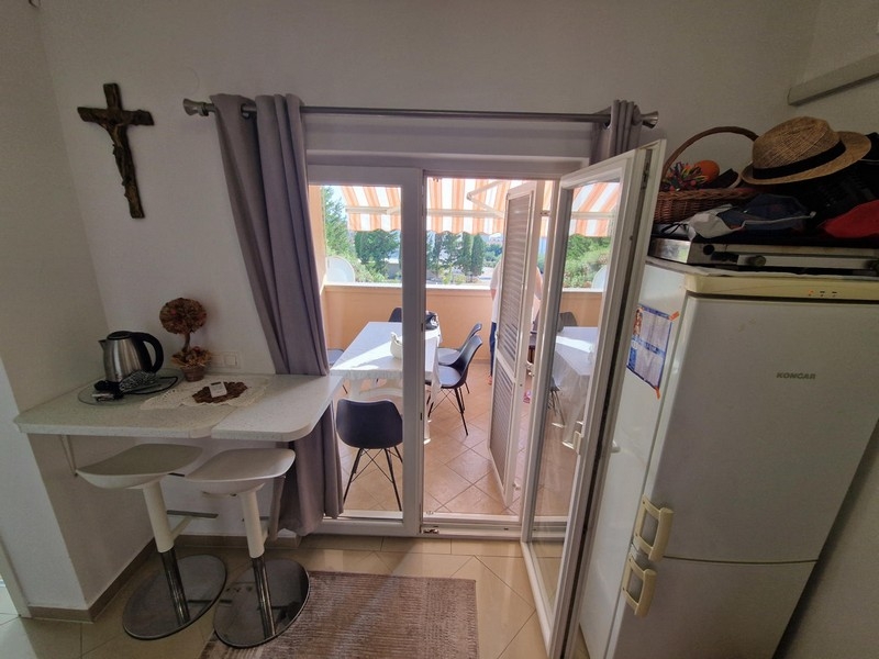 Pièce de vie avec coin cuisson et porte de la loggia