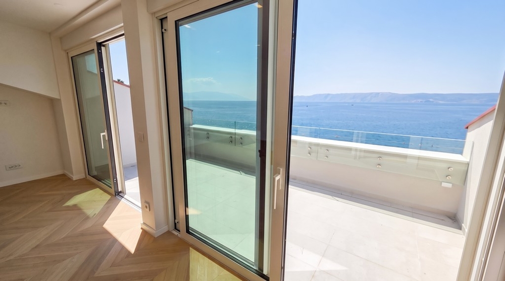 Vue à travers les portes vitrées sur la terrasse et la mer
