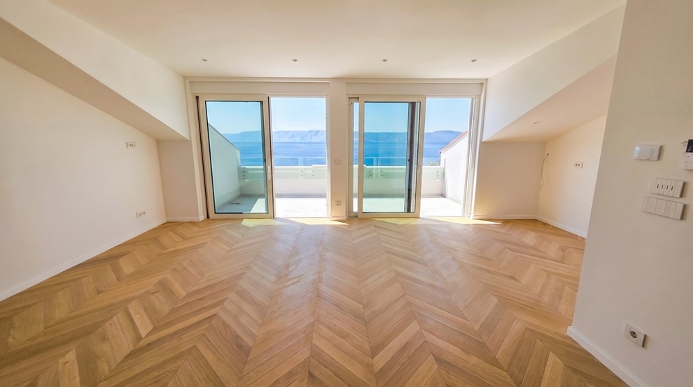 Pièce de vie avec parquet en point de Hongrie et accès à la terrasse