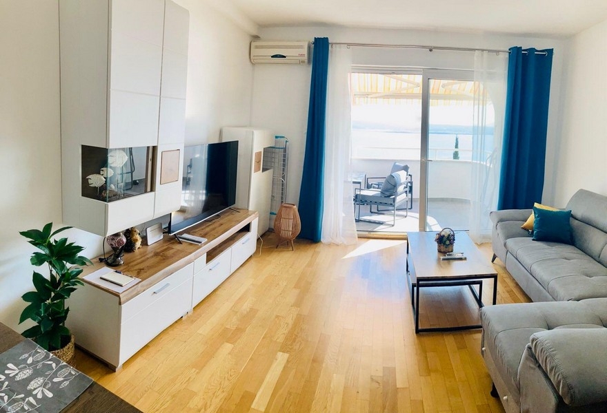 Salon avec climatisation et porte donnant sur le balcon