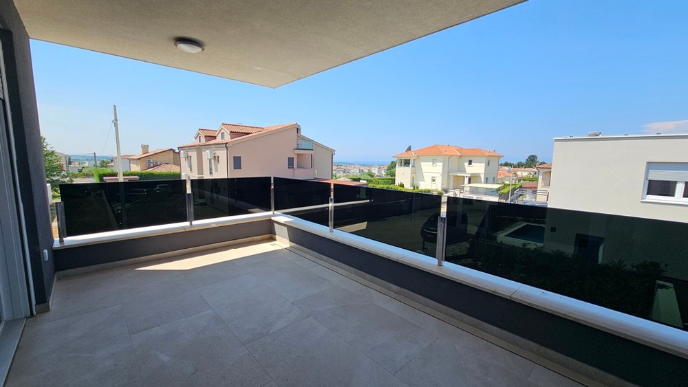 Terrasse couverte avec garde-corps en verre et vue sur les environs