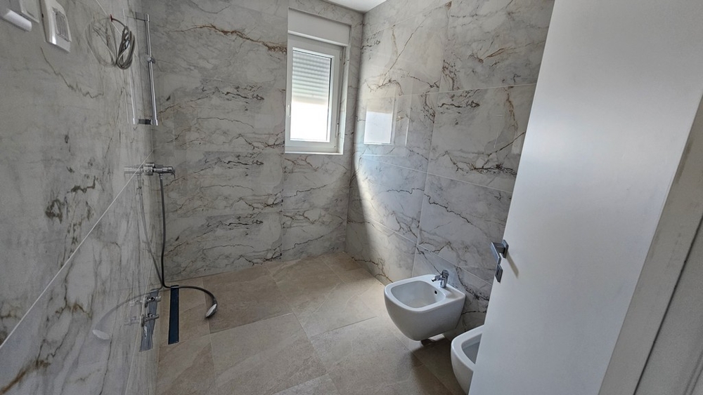 Salle de bains moderne avec douche et aspect marbre