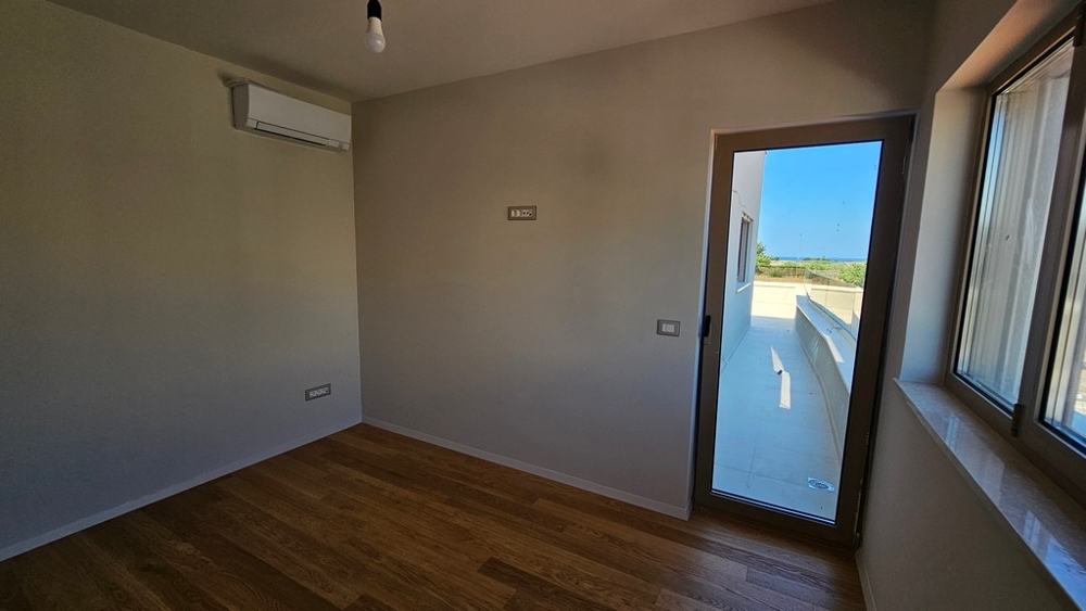 Chambre avec porte donnant sur la terrasse et vue vers la mer