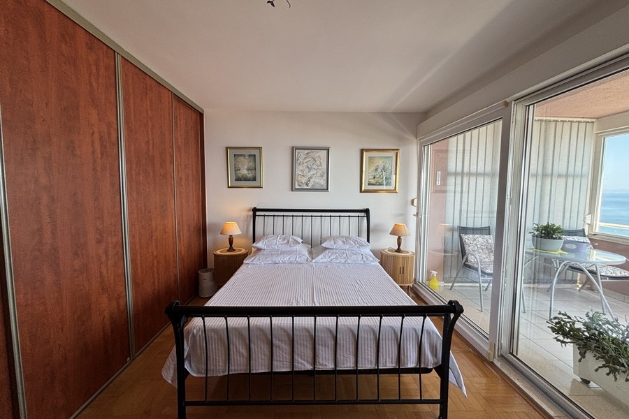Chambre avec placard intégré et accès à la loggia