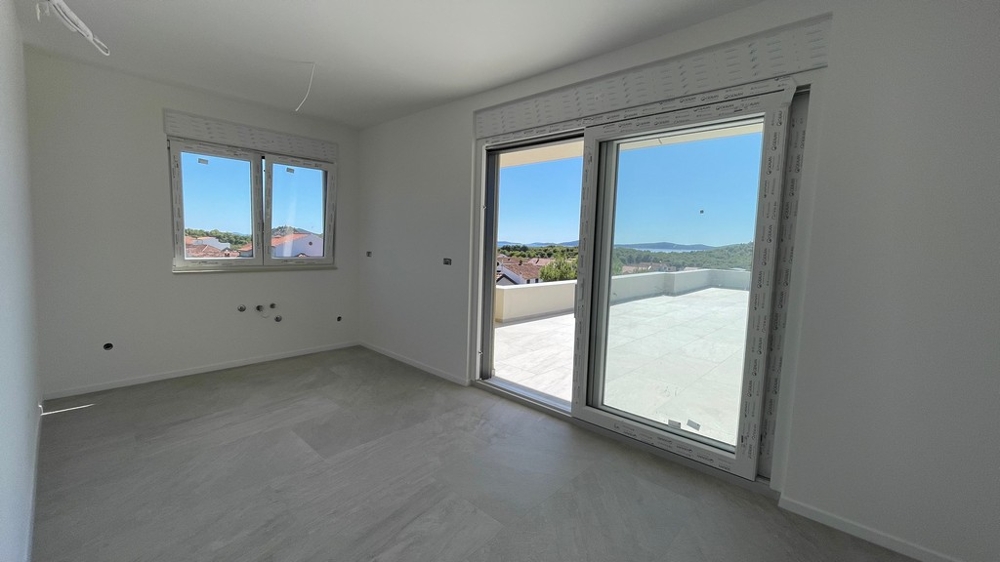 Pièce avec porte coulissante donnant sur la terrasse et vue mer dans la construction neuve A4073 à Tribunj