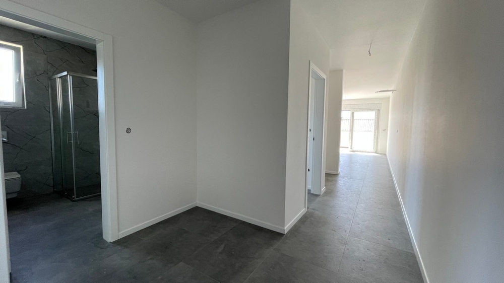 Pièce de vie avec cuisine ouverte et porte donnant sur la terrasse, appartement neuf A4073 à Sovlja