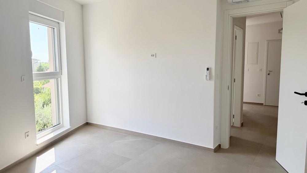 Pièce avec fenêtre et accès au couloir