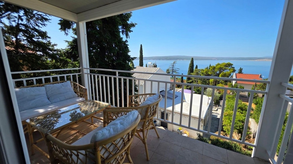Balcon avec meubles en osier et vue mer