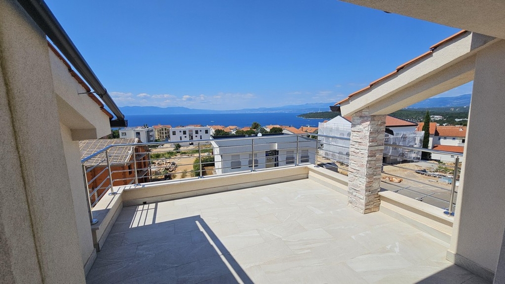 Toit-terrasse avec colonne en pierre naturelle et vue sur le village jusqu'à la baie