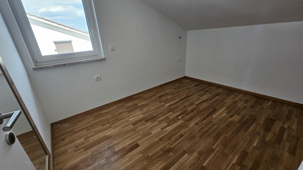 Chambre avec fenêtre de toit et parquet