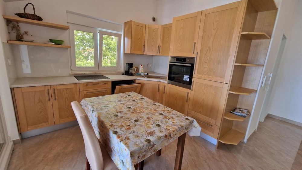 Kitchenette en bois avec coin repas dans l'appartement à Njivice