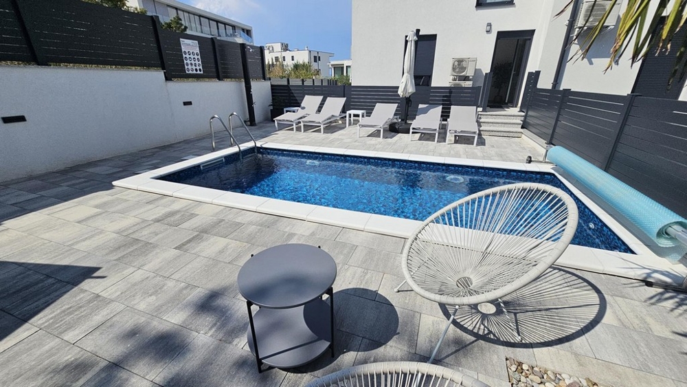 Piscine chauffée avec bains de soleil dans le jardin de l'appartement à Malinska sur Krk