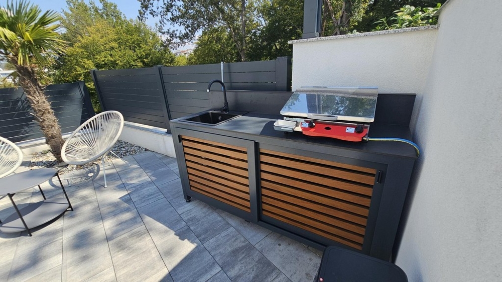 Cuisine d'été avec coin barbecue dans le jardin de l'appartement à Malinska