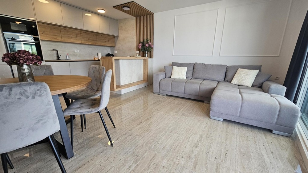 Séjour et coin cuisine ouverts avec canapé et table à manger à Malinska