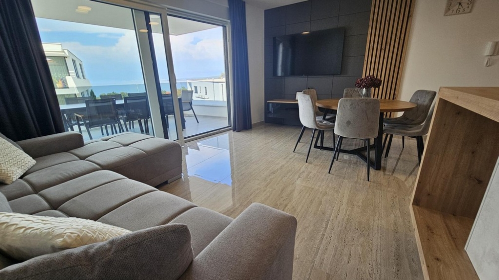 Séjour avec grande baie vitrée et vue sur la terrasse et la mer