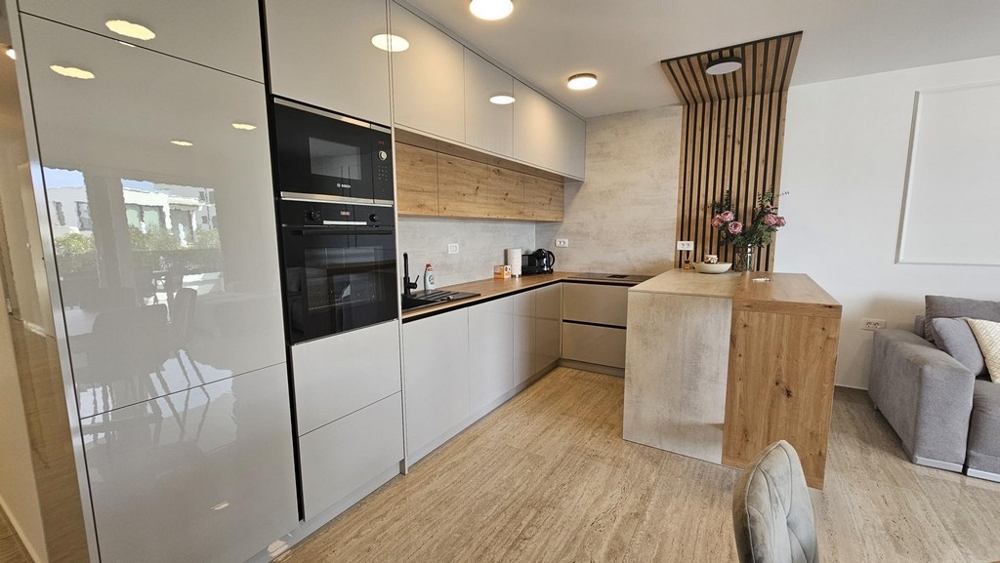 Cuisine équipée moderne avec façades brillantes et éléments en bois