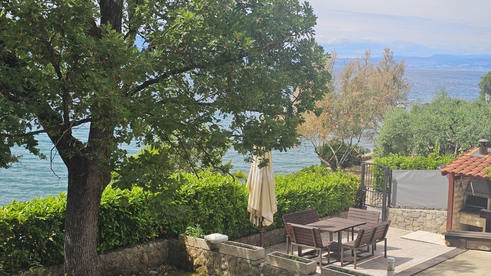 Terrasse en bord de mer avec parasol et coin salon à Malinska