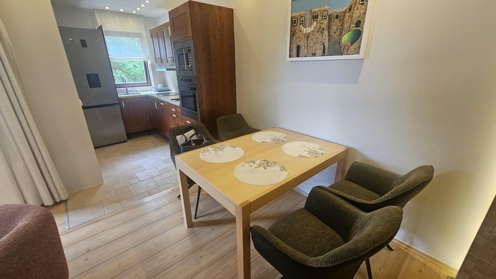 Espace repas avec table en bois et vue sur la cuisine