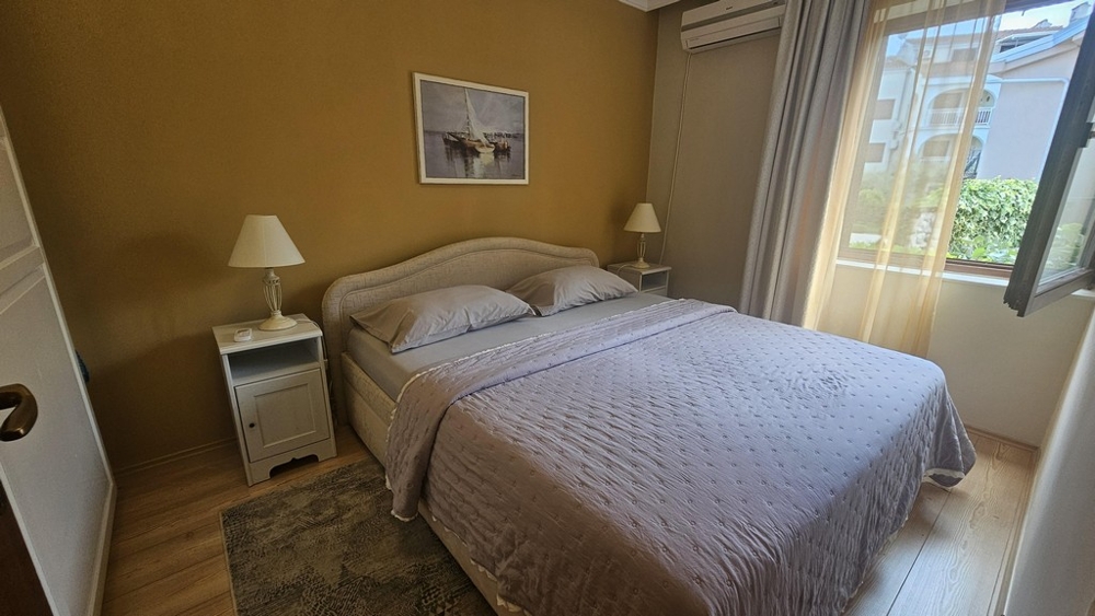 Chambre avec lit double et fenêtre donnant sur le jardin